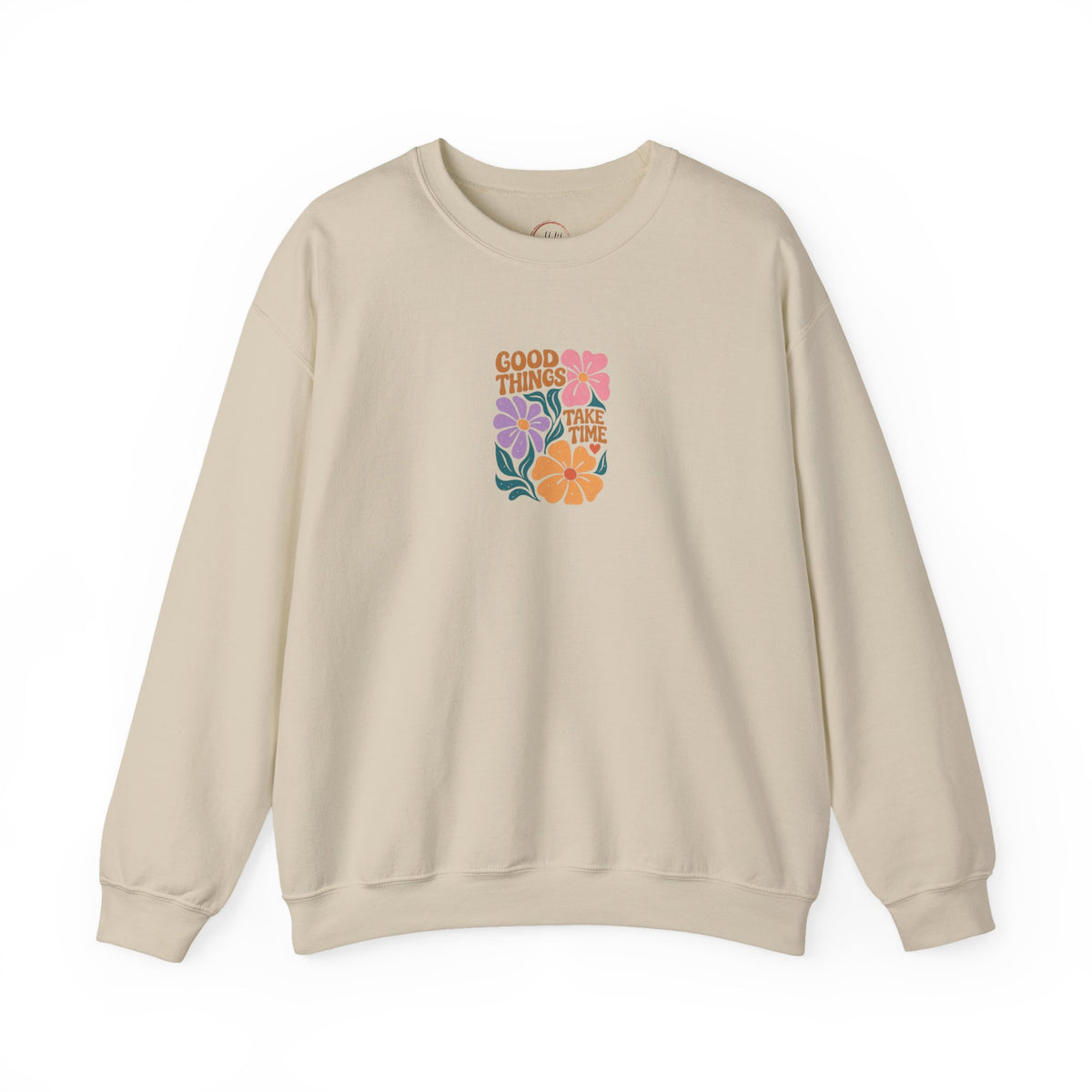 A beige crewneck sweatshirt with a colorful retro-style floral graphic on the chest that reads 'GOOD THINGS COME TO THOSE TIMES' in orange and purple text, surrounded by pink, purple, orange, and green flowers. The sweatshirt is displayed flat against a clean white background.