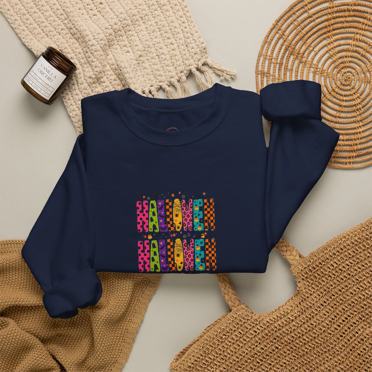 Navy blue sweatshirt with a colorful design on a neutral surface with textured items.