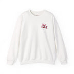 An off-white crewneck sweatshirt with a small red and pink graphic on the left chest, displayed on a clean white background.